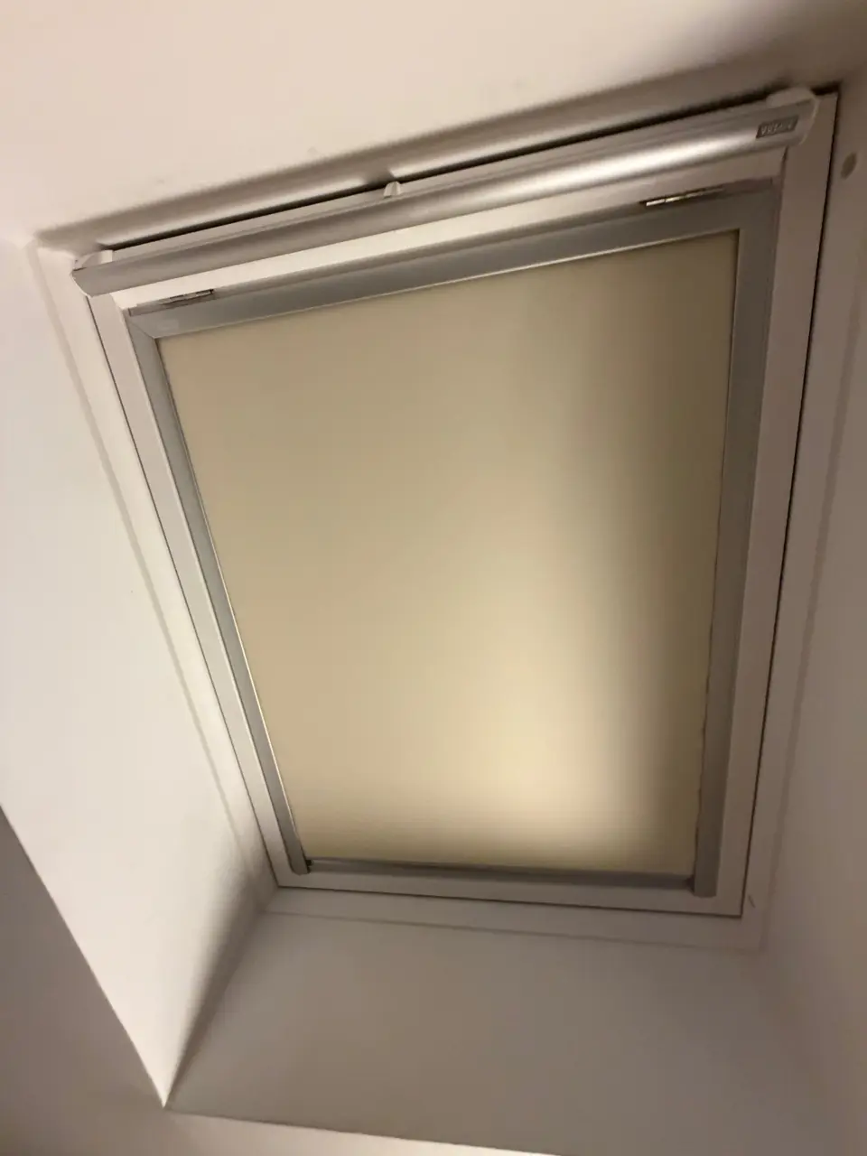 Fenêtre de toit avec store intérieur dans une pièce sous combles