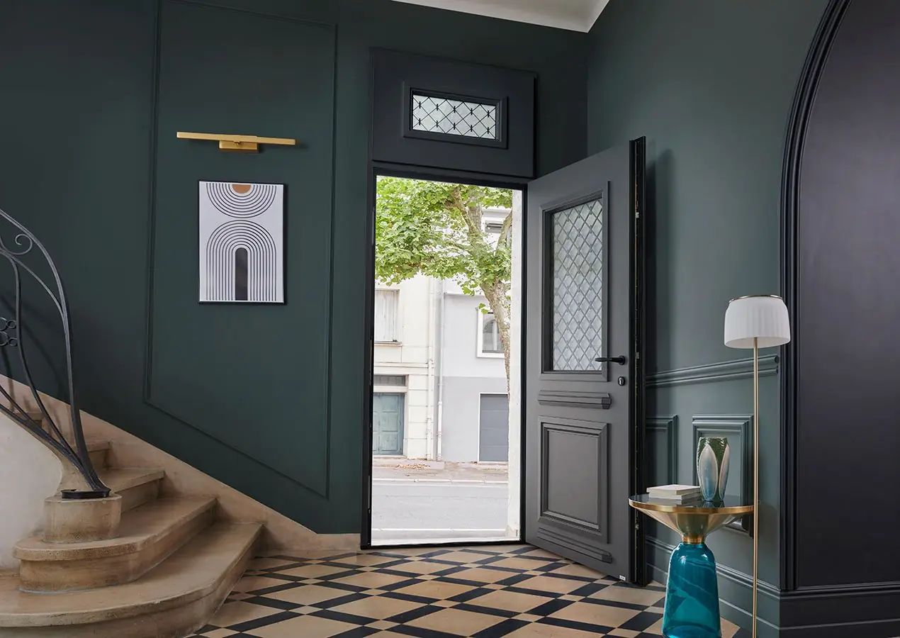 Porte d'entrée en verre avec cadre en métal dans un hall moderne.