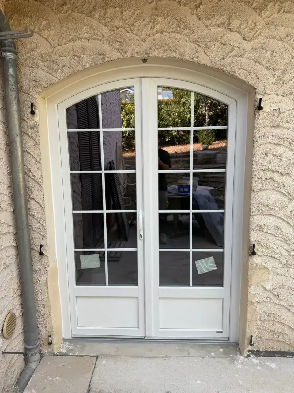 Portes en PVC blanches avec vitrage en grille pour entrée élégante.